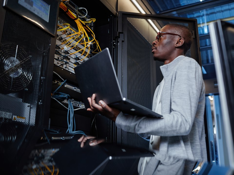 Young attractive multicultural laughing couple walking outdoors and visiting city. Man having map in his hands. Tourism concept.